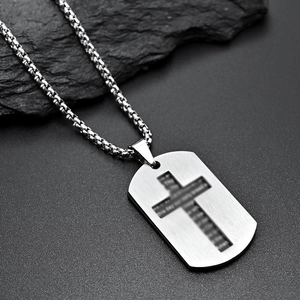Macro shot of stainless steel dog tag necklace with engraved cross and Amen scripture