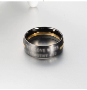 Dettaglio macro dell'anello in titanio nero e oro con incisione True Love Waits