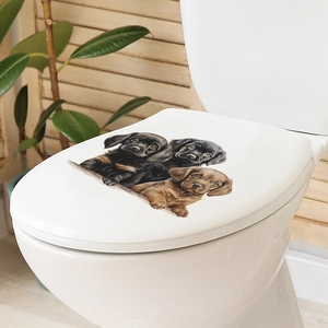 Close-up of waterproof puppy wall stickers applied to a white ceramic toilet lid