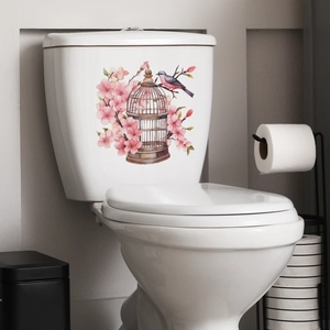 Detail view of decorative pink cherry blossom and birdcage sticker on a toilet tank