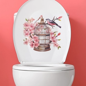Watercolor birdcage and cherry blossom decal on a white toilet lid against a red wall