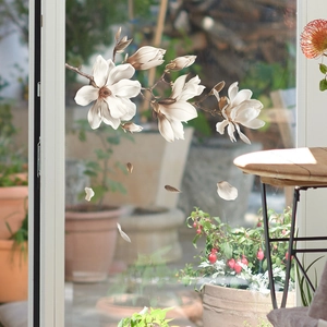 Detailed view of white magnolia static glass window film set applied on transparent door