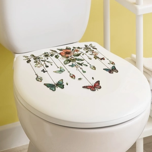 Macro shot of floral and butterfly decals applied to a white ceramic toilet lid