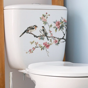 Detail view of floral wall sticker featuring birds and pink plum blossoms on toilet tank