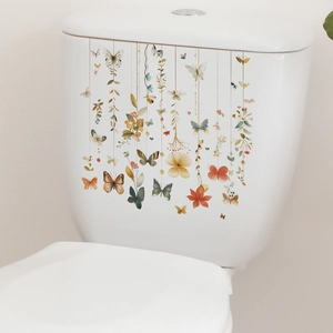 Detail of colorful butterfly and flower stickers on a white ceramic toilet tank surface