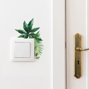 Detail showing tropical monstera leaf wall stickers applied around a light switch