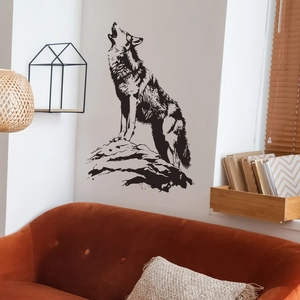Modern black wolf silhouette wall sticker applied above a stylish orange velvet sofa