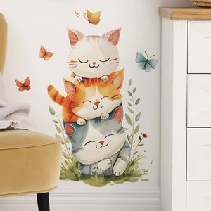 Detailed view of hand-painted cartoon cats stacking wall stickers in a cozy nursery room