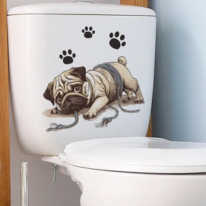 Cute pug puppy toilet seat decal with black paw prints on white ceramic background