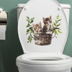 Watercolor cat and green leaves decal shown on a white ceramic toilet lid in a bathroom