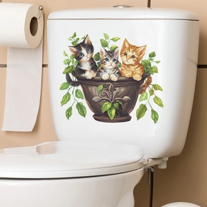 Detail of cute cartoon kittens and green leaves decorative sticker on a white toilet