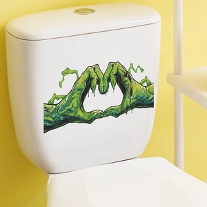 Close-up of green zombie hands heart-shaped sticker on a white toilet tank lid