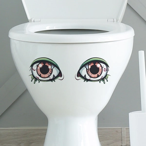 Detail of spooky cartoon bloodshot eyeballs decals applied on a white ceramic toilet