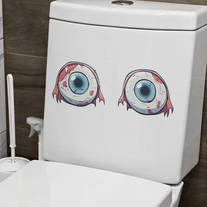 Macro detail of scary bloodshot eyeball decals on a white bathroom toilet tank surface