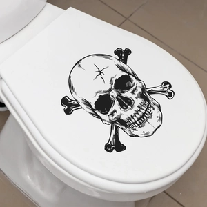 Detail of hand-drawn skull and crossbones waterproof PVC sticker on a white toilet lid