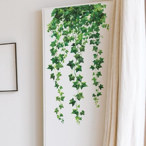 Detail of lifelike green vine wall decals showing natural leaves on a white wall decor