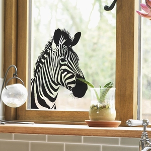 Modern zebra pattern window film on glass window with green plants background
