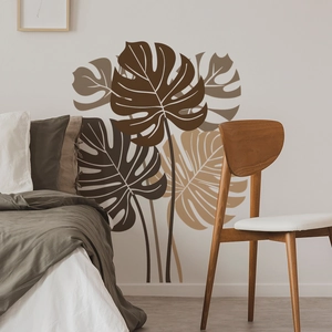 Minimalist monstera leaf wall decals in earthy tones for a modern bedroom background