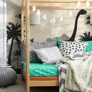 Detailed view of cartoon dinosaur forest wall stickers in a cozy kids bedroom setting