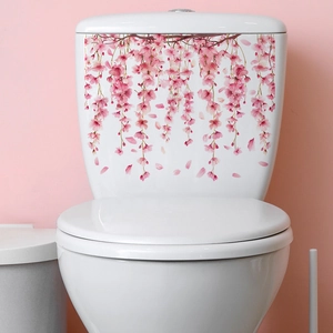 Detail showing decorative pink cherry blossom decals on a white ceramic toilet tank