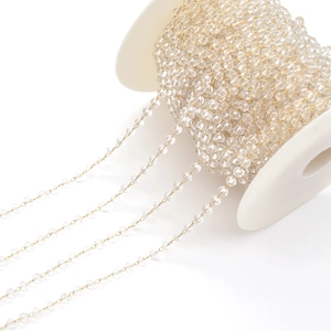 Macro detail of faceted clear crystal beads on golden wire for DIY jewelry making