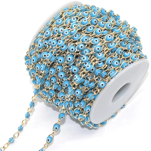 Macro shot of gold chain with blue evil eye beads for DIY jewelry making material