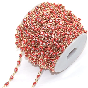 Detail of red evil eye beads on a golden chain roll for DIY jewelry making
