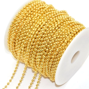 Macro view of bright golden ball chain neatly wound on a spool for DIY jewelry crafts