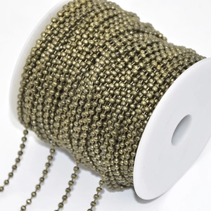 Close-up of antique bronze metal ball chain neatly wound on a white plastic spool for DIY