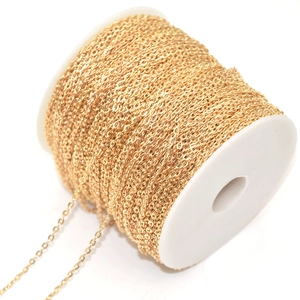 Golden flat cross chain roll for DIY jewelry making on white plastic spool
