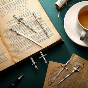 Set of 7 vintage alloy sword and weapon pendants on an antique book background