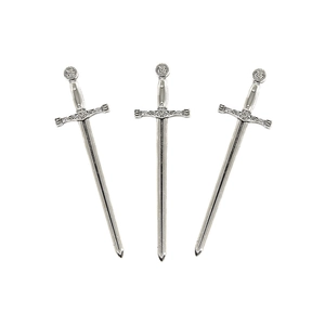 Macro shot of three vintage alloy miniature swords with detailed medieval engravings