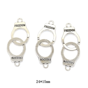 Macro shot of vintage silver handcuffs charms with freedom engraving measuring 24 by 15mm