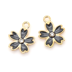Detail of dark grey enamel cherry blossom charms with gold plating and white rhinestones