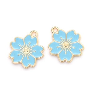 Detailed view of two sky blue enamel cherry blossom charms with gold-plated metal edges