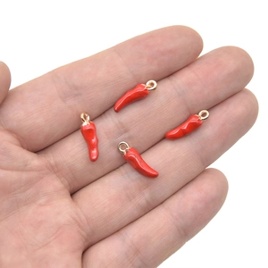 Set of four red enamel chili pepper pendants with gold rings shown on a hand for scale