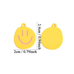 Detailed view of yellow smiley face charms with pink eyes and sunburst texture back