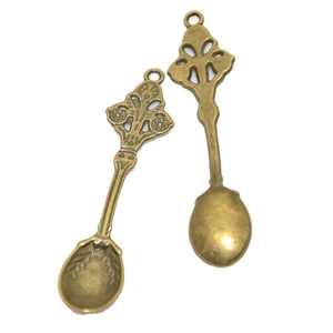Pendaglio a cucchiaio vintage in lega di bronzo con rilievo floreale su fondo bianco