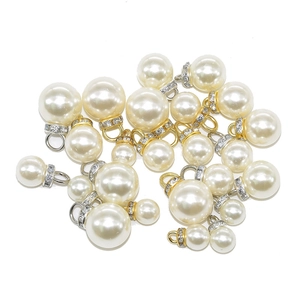 White ABS pearl pendants with rhinestone eyelets in gold and silver plating
