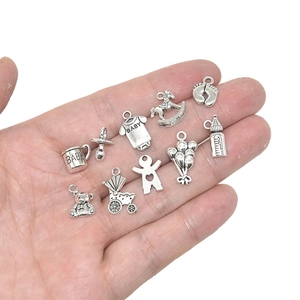 Silver baby-themed alloy charms set held in hand for DIY jewelry making accessories