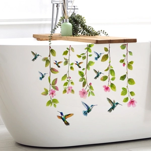 Détail des stickers de colibris et de fleurs appliqués sur une baignoire blanche