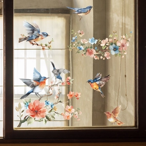 Detailed view of floral and bird static window decals on a wooden frame glass window