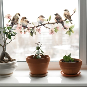 Detail of floral window film showing pink cherry blossoms and small birds on a bright window