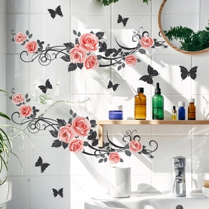 Détail de stickers de roses roses et papillons noirs sur carrelage blanc de salle de bain