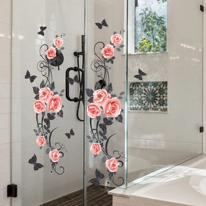 Détail de stickers électrostatiques roses et papillons noirs sur une porte de douche