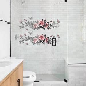 Détail de stickers roses et papillons électrostatiques sur une porte de douche en verre