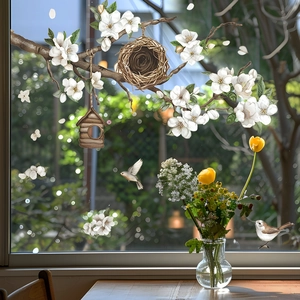 Detail of floral window decals with birds, tree branches, and nests in natural daylight