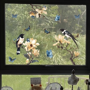 Detail of static window film showing hand-painted magnolia flowers and blue butterflies