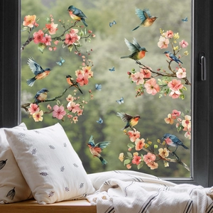 Detailed view of floral bird static window decals on glass with soft pink blossoms