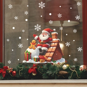 Christmas window sticker featuring Santa Claus on a roof with a gingerbread man and snowballs